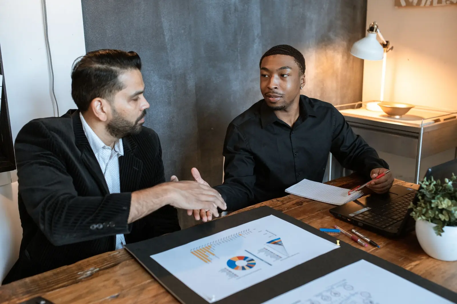 Consultant walking a business owner through charts on a tablet