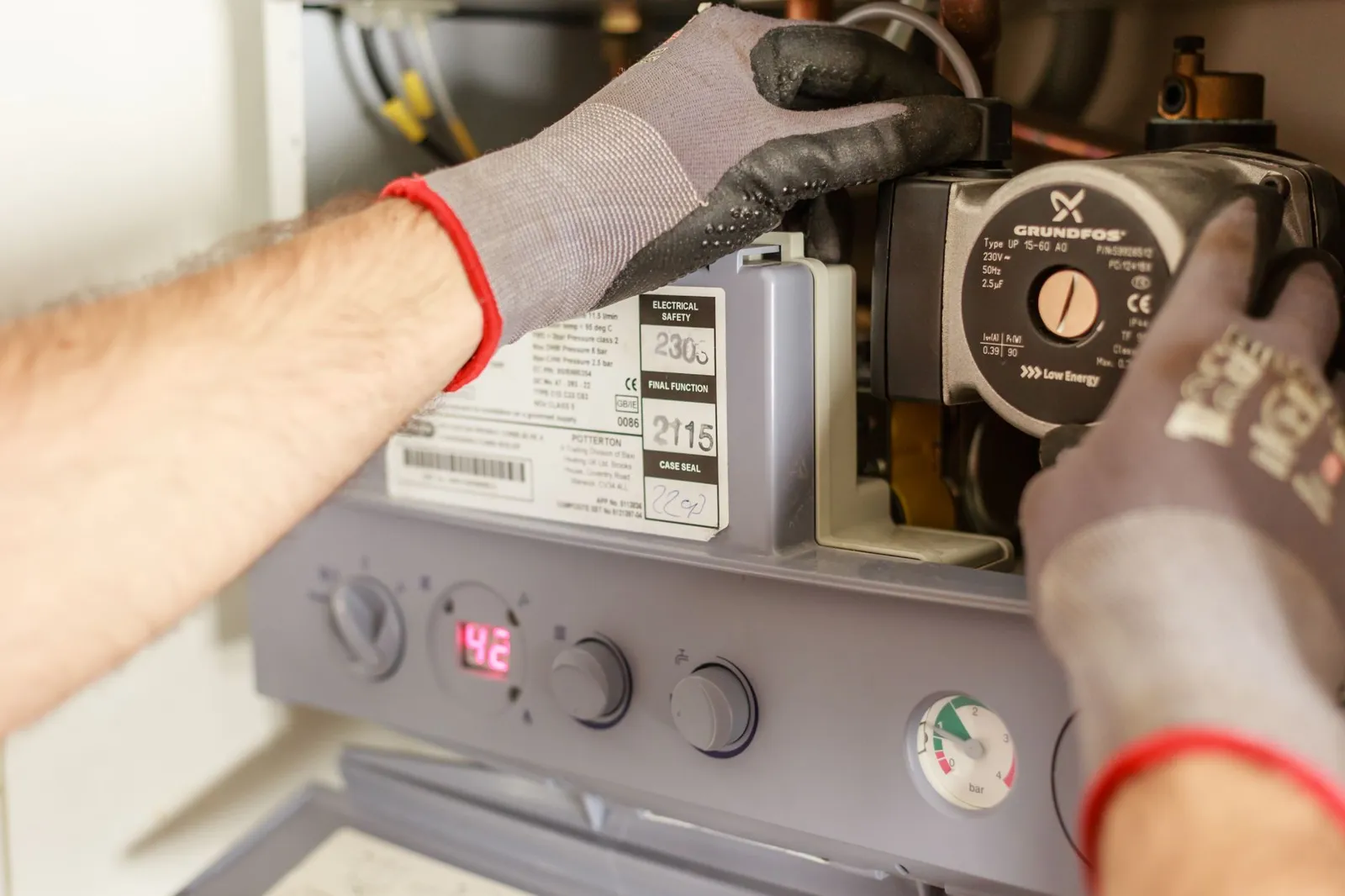 Technician in work gloves servicing a furnace