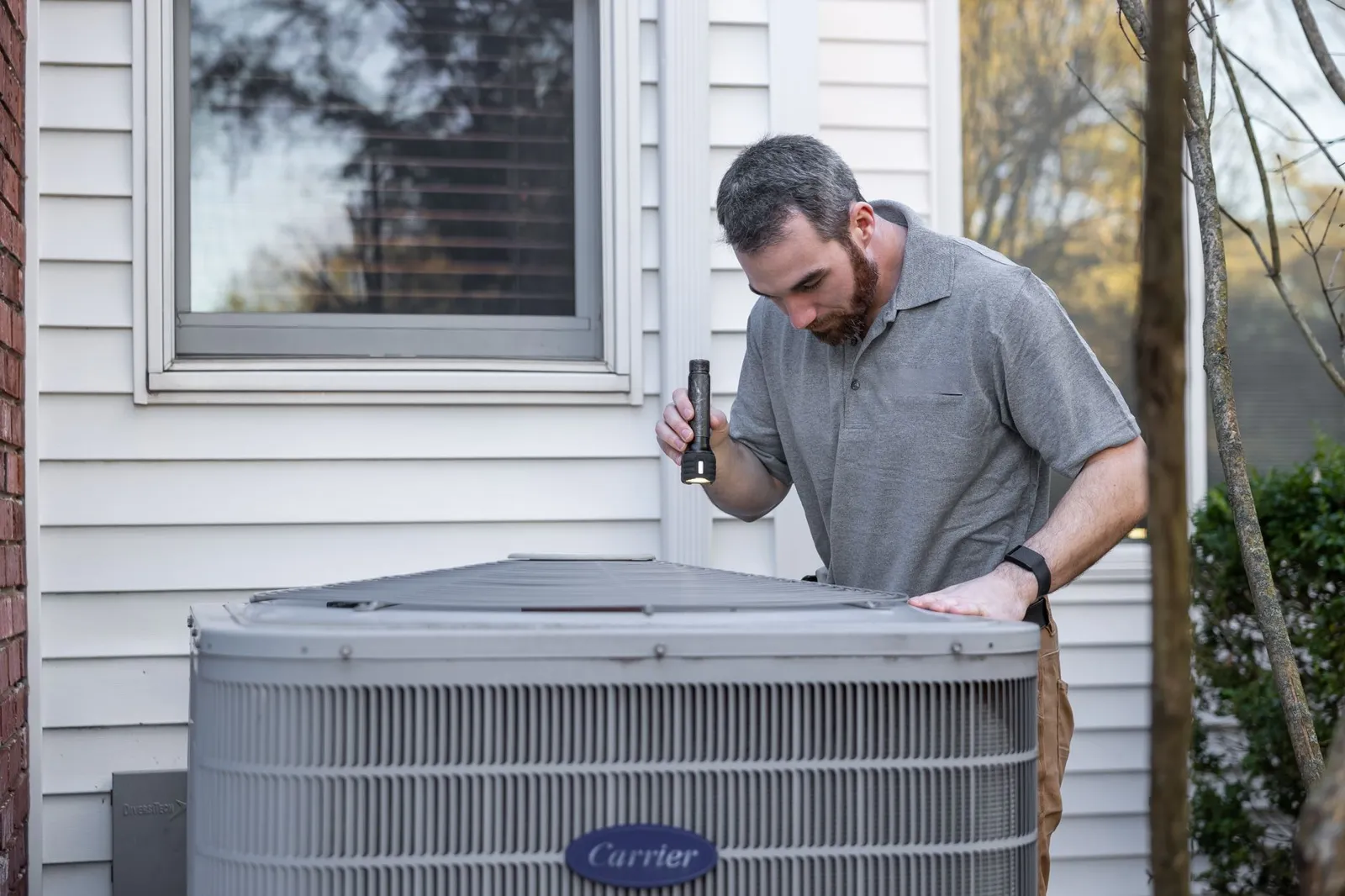 HVAC technician checking a home air conditioner unit