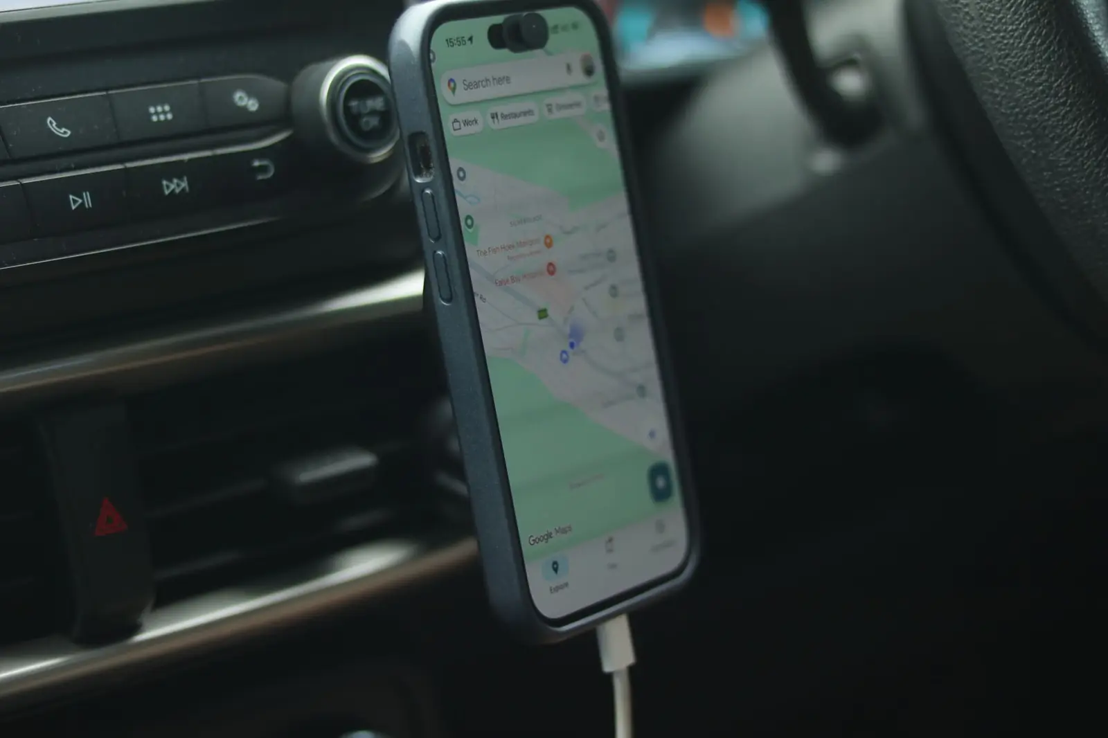 Phone showing a map app on a car dashboard