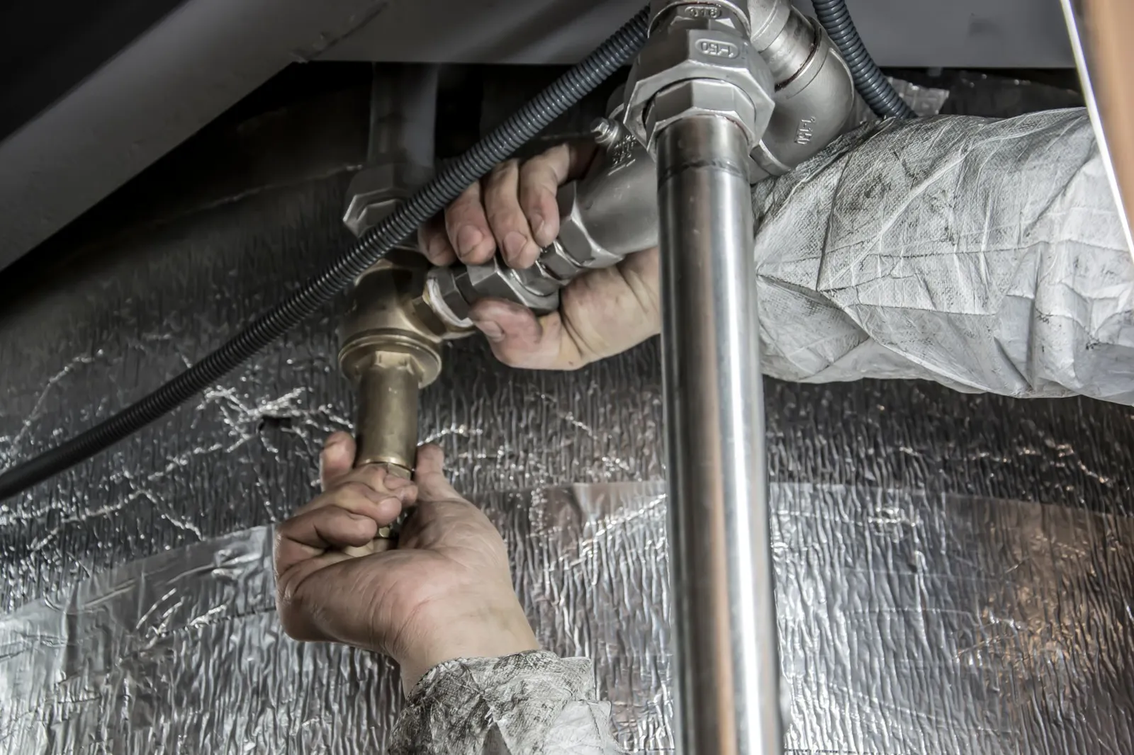 Plumber connecting copper and steel pipe fittings